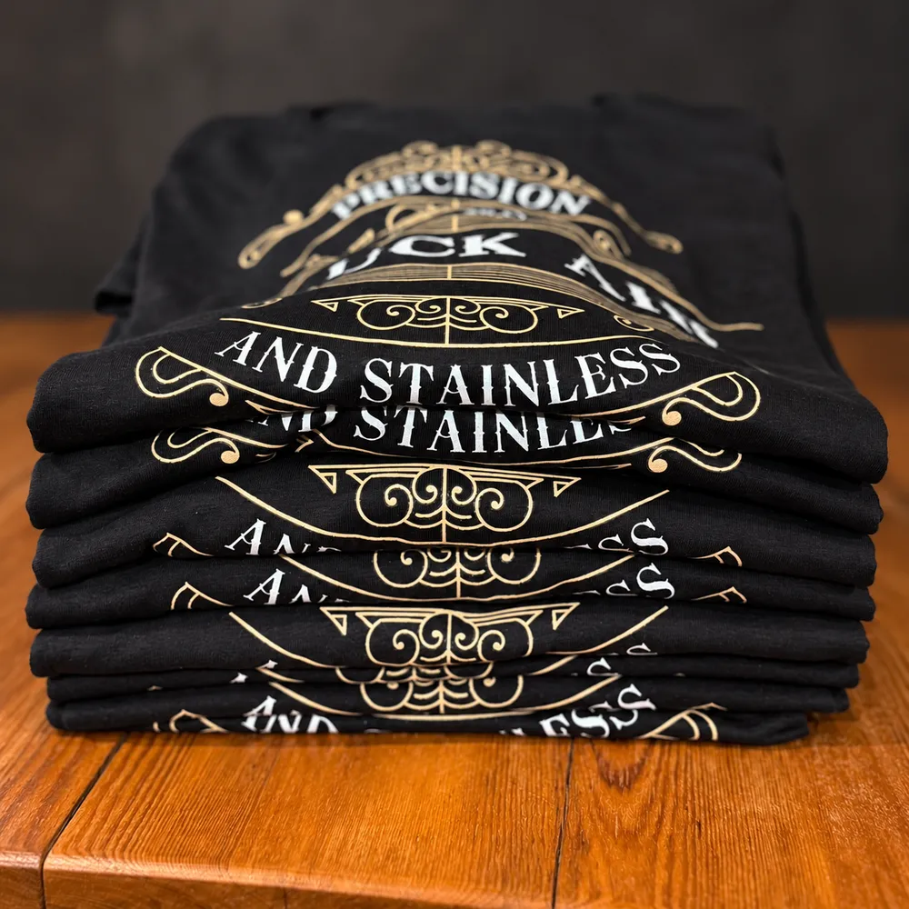 a stack of black tees, gold print
